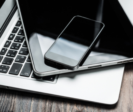 Laptop and smartphone on desk – digital tools to access home equity through cash-out refinance, second mortgage, or HELOC.